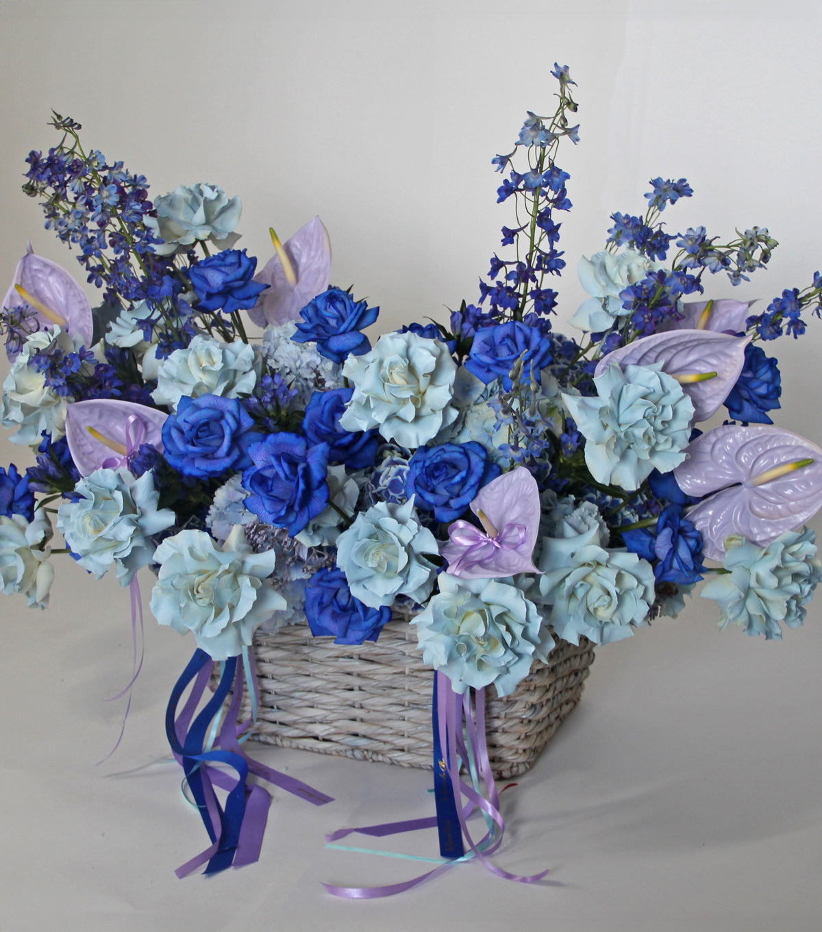 “Crown” – wicker basket of blue roses and hydrangea by La Grande Beauté, luxury flower delivery London