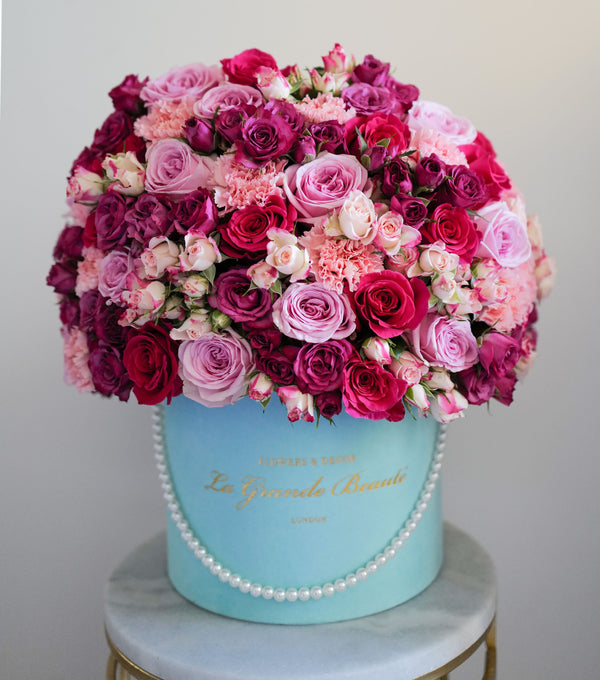 ''XOXO'' this stunning box of classic blush and hot pink roses, spray roses and carnations. The arrangement in the photo is in the blue 25cm "La Grande Beaute" velvet box decorated with white pearl string. Luxury London delivery